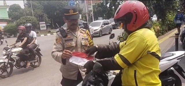 Sambut Kemerdekaan, Polisi Jembatan Besi Bagikan Bendera kepada Warga